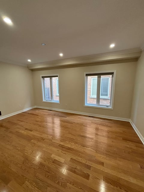Empty modern room with hardwood floor and cream walls
