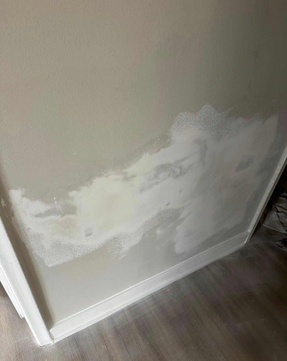 A bathtub filled with white foam and soapy water, viewed from above on a wooden floor