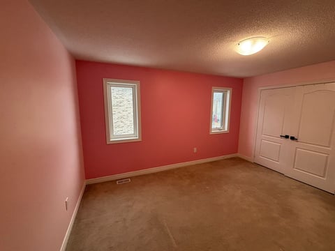 Empty bedroom with coral red accent wall