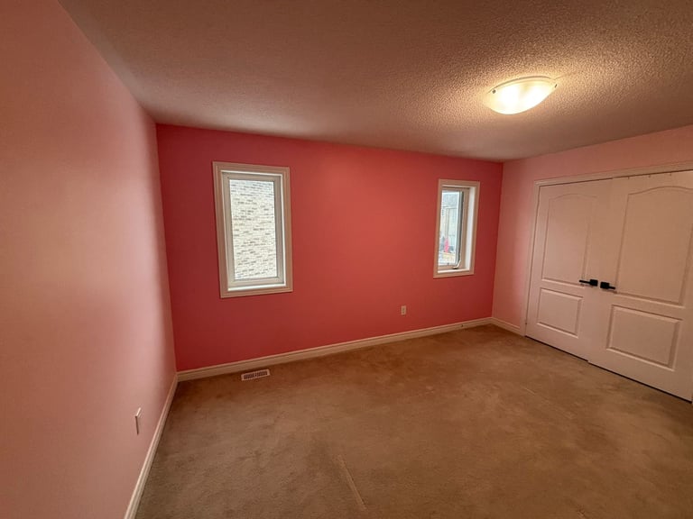Empty bedroom with coral red accent wall