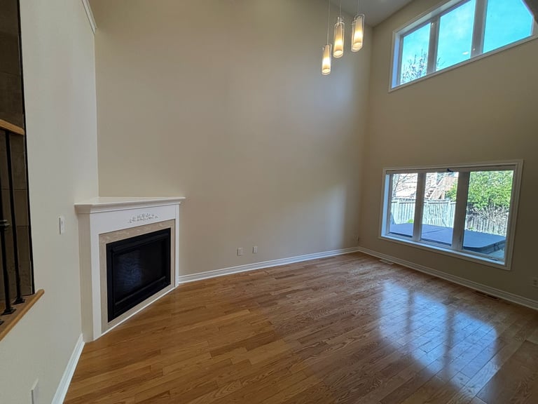 Empty living room with fireplace and large windows